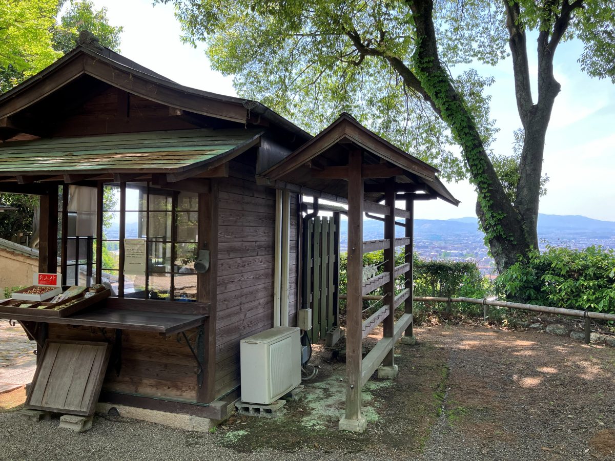 Byakugoji's reception — a small wooden building, with the city of Nara and distant mountains visible beyond it