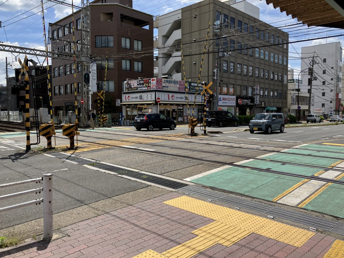 The railway level crossing outside Shin-Omiya Station with warning barriers